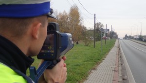 Na zdjęciu policjant dokonuje pomiaru prędkości.