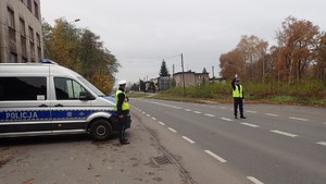 Na zdjęciu policjant, który daje sygnał do zatrzymania dla nadjeżdżającego pojazdu.