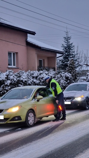 Kierowca dmucha w urządzenie do badania stanu trzeźwości.