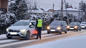 Policjant sprawdza stan trzeźwości przejeżdżających kierowców.