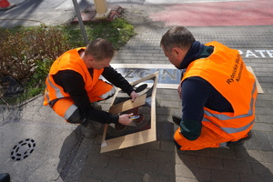 Na zdjęciu pracownicy rybnickich służb komunalnych malują napisy przed przejściem dla pieszych.