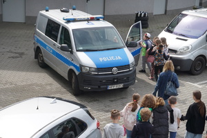 Na zdjęciu dzieci, które odwiedziły rybnicką komendę oglądają policyjne radiowozy.