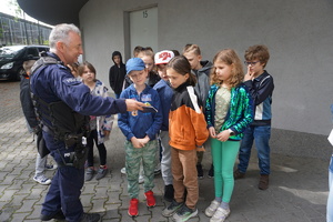 Na zdjęciu przewodnik psa służbowego rozmawia z dziećmi o bezpiecznych zrachowaniach.