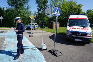 Na zdjęciu policjant ruchu drogowego ocenia jazdę na rowerze uczniów, którzy zakwalifikują się  do etapu wojewódzkiego Ogólnopolskiego Turnieju Bezpieczeństwa w ruchu drogowym.