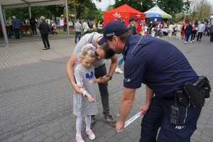 Na zdjęciu policjant wręczył dziewczynce odbalsk.