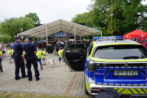 Na zdjęciu policjanci oraz oznakowany radiowóz.