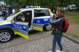 Na zdjęciu chłopiec siedzi za kierownicą radiowozu.