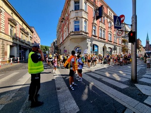 Na zdjęciu przejście pielgrzymów, policjanci z ruchu drogowego dbają o bezpieczeństwo uczestników.