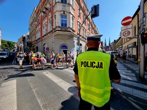 Na zdjęciu przejście pielgrzymów, policjanci z ruchu drogowego dbają o bezpieczeństwo uczestników.