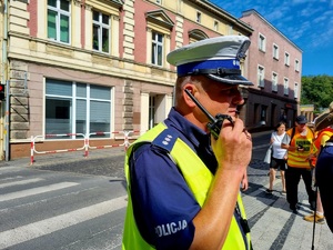 Na zdjęciu przejście pielgrzymów, policjanci z ruchu drogowego dbają o bezpieczeństwo uczestników.