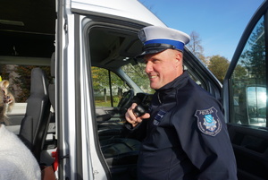 Na zdjęciu policjant z ruchu drogowego rozmawia przez stację.