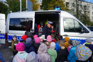 Na zdjęciu policjant prezentuje dzieciom policyjny radiowóz.