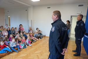 Na zdjęciu umundurowani policjanci z rybnickiej komendy uczą dzieci bezpiecznych zachowań na drodze.