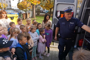 Na zdjęciu policjant prezentuje uczniom ze szkoły w Rybniku policyjny radiowóz.