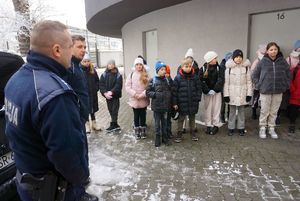 Na zdjęciu umundurowany policjant opowiada uczniom o pracy policjanta.