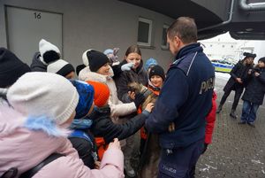 Na zdjęciu policjant ze swoim pupilem i dziećmi.