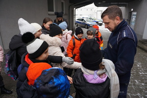 Na zdjęciu policjant i dzieci z policyjnym czworonogiem.