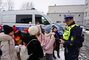 Na zdjęciu dzieci podczas wizyty w rybnickiej komendzie oglądają policyjny motocykl.