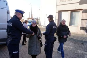 Na zdjęciu policjanci rozdają seniorom odblaski.