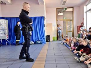 Na zdjęciu policjant prowadzi pogadankę z dziećmi.