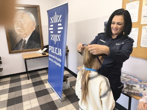 Policjantka wręcza smycz
