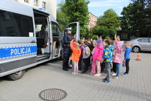 Policjanci pokazują radiowóz.