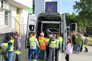 Policjant pokazuje wyposażenie radiowozu.