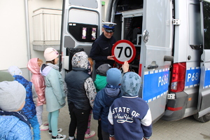 Policjant pokazuje, co znajduje się w radiowozie.
