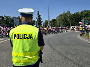 Na zdjęciu policjant podczas zabezpieczenia trasy wyścigu kolarskiego.