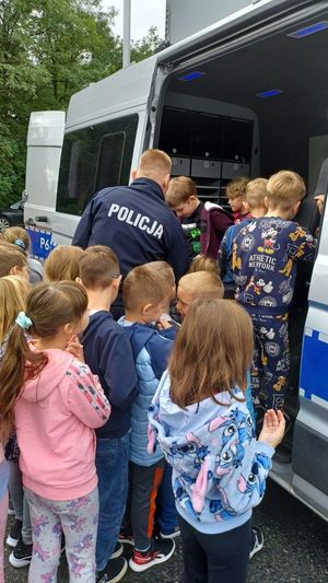 Na zdjęciu trwa Europejski Tydzień Mobilności w Rybniku. Policjant opowiada dzieciom o służbie w Policji.