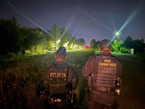 Na zdjęciu policjant oraz strażnik ochrony kolei. W tle tory kolejowe.