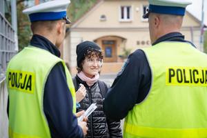 Na zdjęciu policjanci ruchu drogowego rozdają odblaski.
