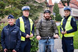 Na zdjęciu policjanci wraz rowerzysta podczas akcji dotyczącej odblasków.