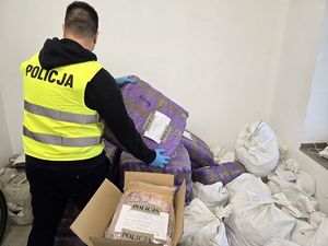 Na zdjęciu policjant wykonujący czynności w magazynie.