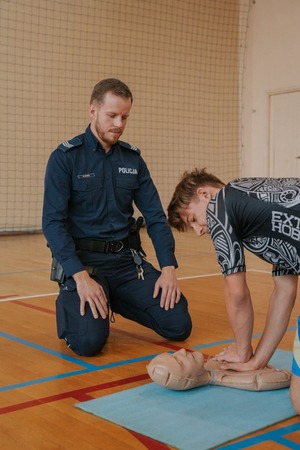 Policjant i uczeń przy manekinie.
