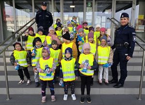 Na zdjęciu przedszkolaki z policjantkami przed komendą. Pamiatkowe zdjęcie.