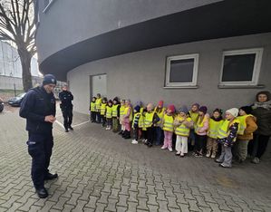 Na zdjęciu przewodnik psa służbowego opowiada dzieciom o swojej pracy.