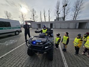 Na zdjęciu dzieci oglądają policyjnego quada.