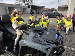 Na zdjęciu dzieci oglądają policyjnego quada.