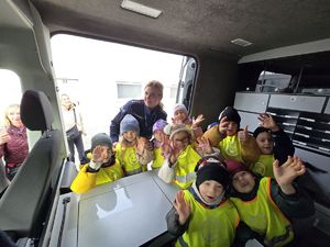 NA zdjęciu dzieci w środku policyjnego radiowozu.