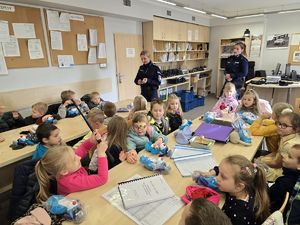 Na zdjęciu policjantki prezentują dzieciom policyjny sprzęt.