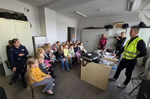 Na zdjęciu technik kryminalistyki opowiada przedszkolakom o swojej pracy.