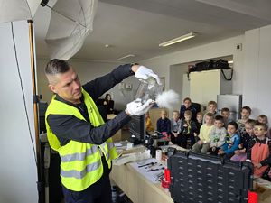 Na zdjęciu technik kryminalistyki opowiada przedszkolakom o swojej pracy.