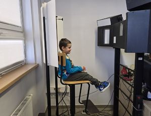 Na zdjęciu chłopiec, któremu technik wykonuje zdjęcie.