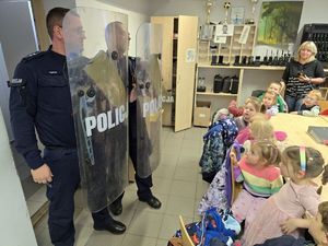Na zdjęciu maluszki z przedszkola uważnie słuchają o służbie w Policji.