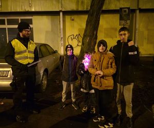 Na zdjęciu policjanci wraz z mieszkańcami podczas akcji rozdają odblaski.