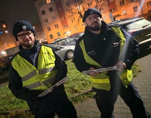 Na zdjęciu policjanci wspólnie z przedstawicielami samorządu rozdają mieszkańcom odblaski.