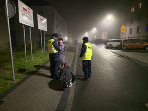 Na zdjęciu policjanci wspólnie z przedstawicielami samorządu rozdają mieszkańcom odblaski.