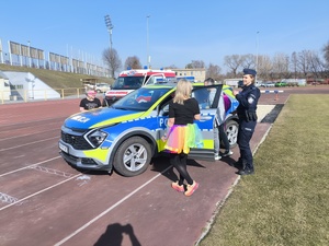 Osoby oglądają radiowóz.