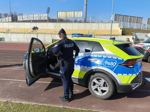 Policjantka pokazuje radiowóz.